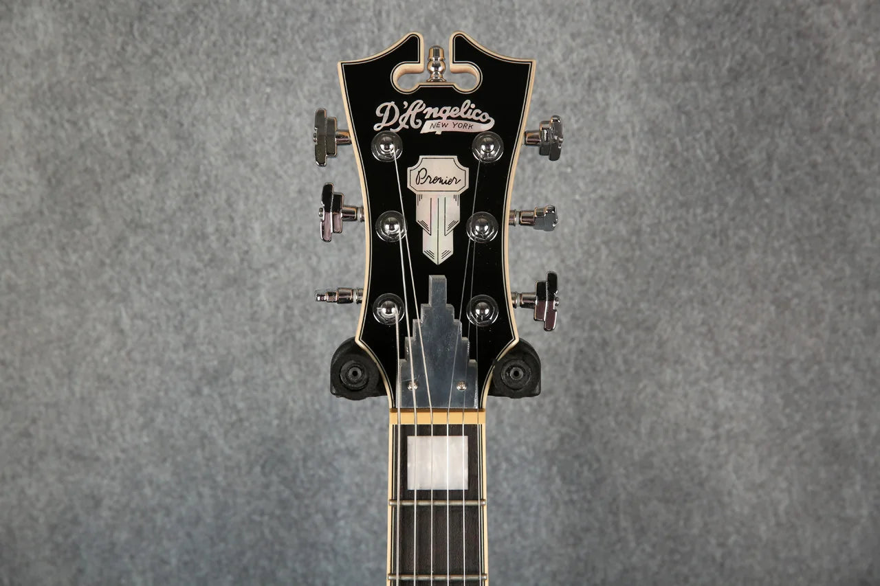 D'Angelico Premier Bedford guitar in oxblood red with a natural wood finish, shown with a gig bag, front view.