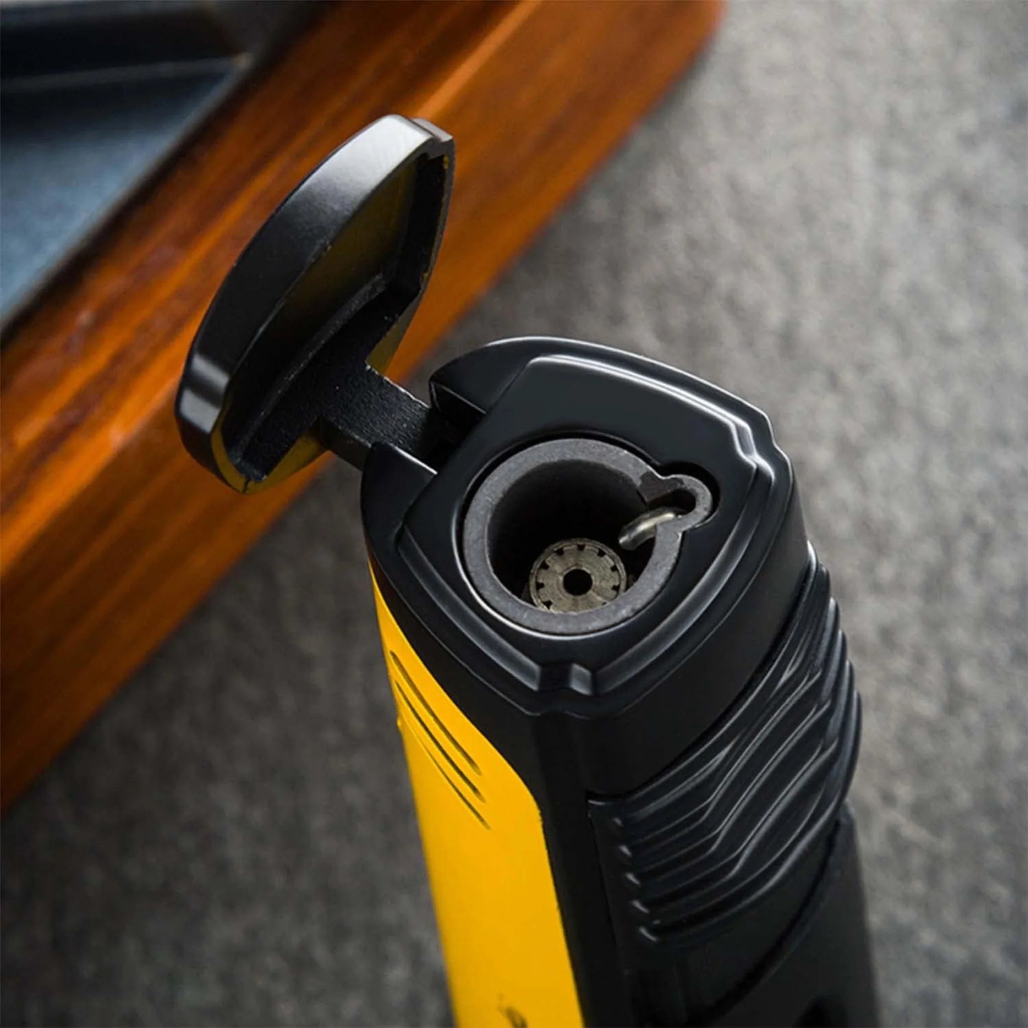 Lubinski cigar jet lighter with yellow flip-top lid, open to reveal the ignition mechanism and flame adjustment.