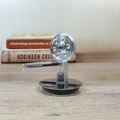 Mini low temperature Stirling engine from Stirling, showing the compact metal engine with visible pistons and flywheel in operation.