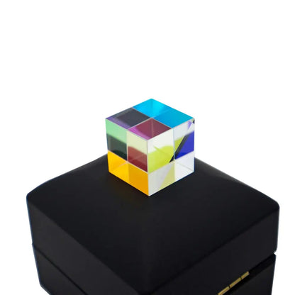 VOT Certified mini crystal cube optical glass prism sun catcher displayed on black box with reflections and vibrant light effects.