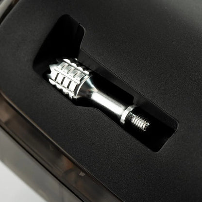 Metallic screw or bolt in a black plastic holder on a dark background
