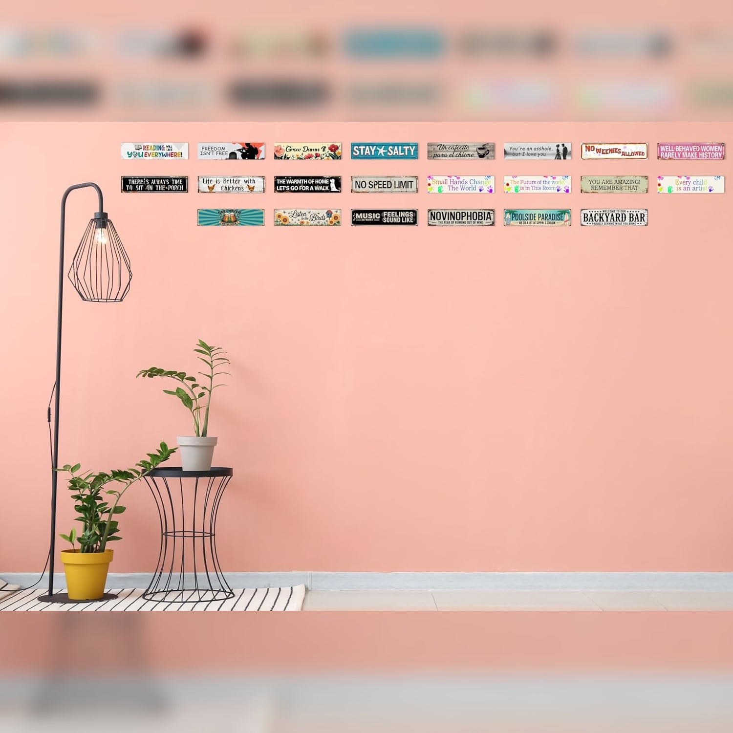 Decorative setup with a floor lamp, table, and potted plants against a pink wall.